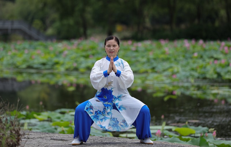 7月23日，太极拳爱好者在龙潭古寨荷花旁边练习。