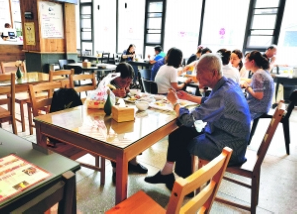 市民在民生路惠民菜場社區食堂就餐。