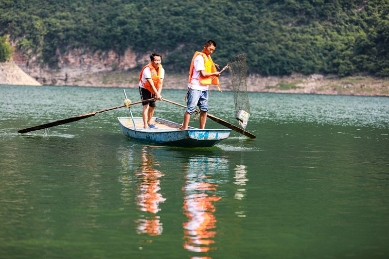 2022年7月27日，村民在贵州省黔西市金兰镇瓦房寨村错界河内打捞水面漂浮物。