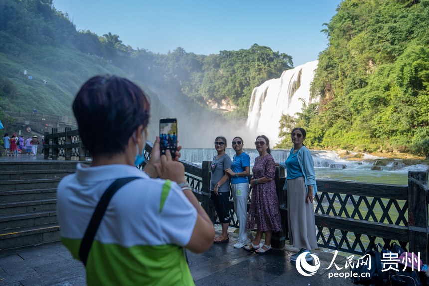 游客在黄果树大瀑布前留影。人民网 皇甫万里摄