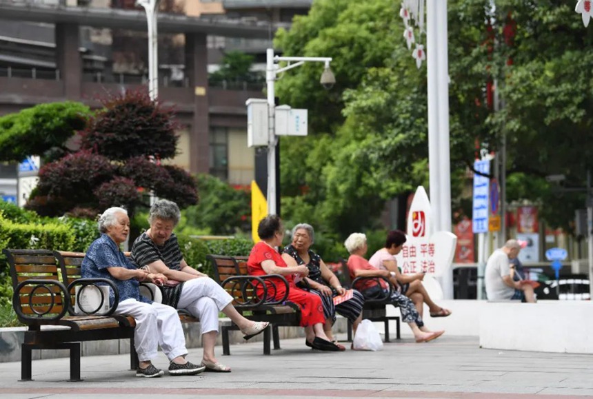 市民在纪念塔小广场“三感”景观小品旁休闲纳凉。