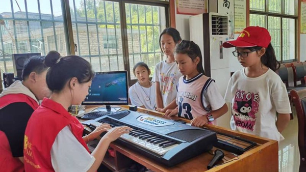 志愿者教小朋友弹电子琴 李宇 摄