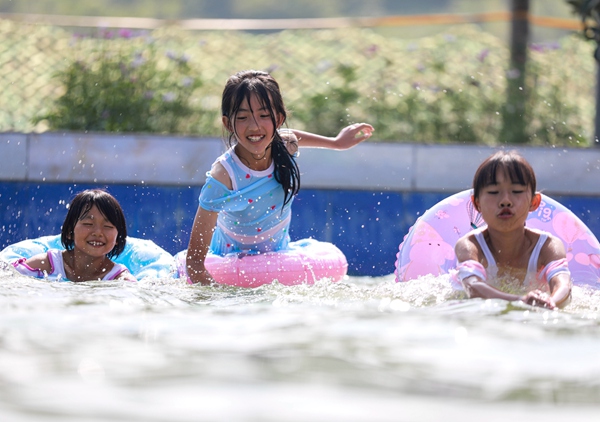 2022年7月31日，学生在贵州省黔西市雨朵镇平坝村游泳池里练习游泳的基本技能。