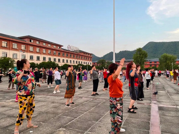 2.重慶游客與當地群眾舞在一起、樂在一起。陳澤珊攝