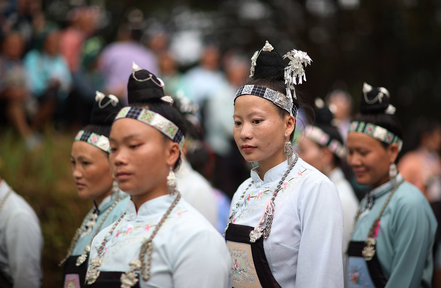 8月5日，盛裝打扮的苗族村民在山頂上跳蘆笙舞。