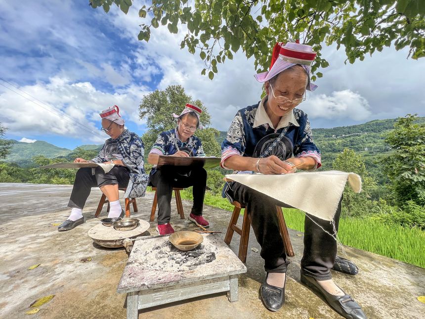 2022年8月6日，贵州省黔东南苗族侗族自治州黄平县重安镇望坝村的革家妇女在绘制蜡染图案。
