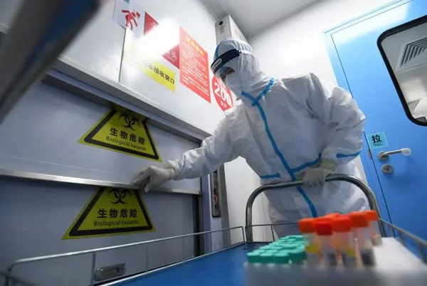 工作人员在标本接收窗口接收待检测标本。