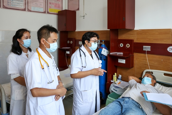 2022年8月17日，在贵州省黔东南苗族侗族自治州施秉县城关镇卫生院，医生在与患者沟通远程会诊后的治疗方案。