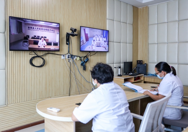 2022年8月17日，在贵州省黔东南苗族侗族自治州施秉县城关镇卫生院远程会诊室，镇卫生院医生通过远程会诊系统与县人民医院专家给一农村患者会诊。 (1)