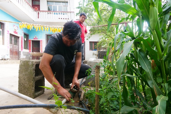 大方县绿塘乡管水员黄太国在营盘村新民组帮农户修水表。