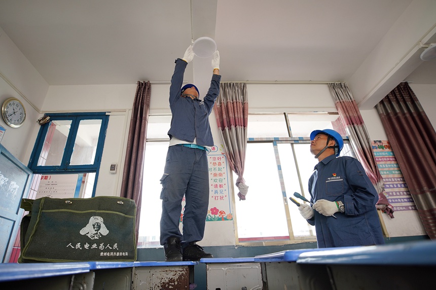 8月28日，在丹寨县城关第二小学，县供电公司的电力工人对教室内照明设备进行检修。