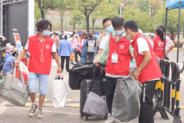 志愿者在帮助新生提行李。