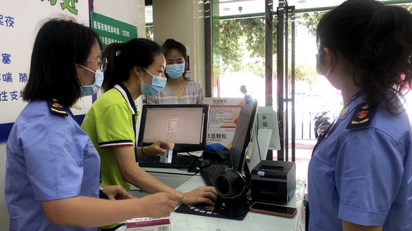 修文县市场监督管理局药品医疗器械监督管理科正在对药店进行检查。郭振东摄