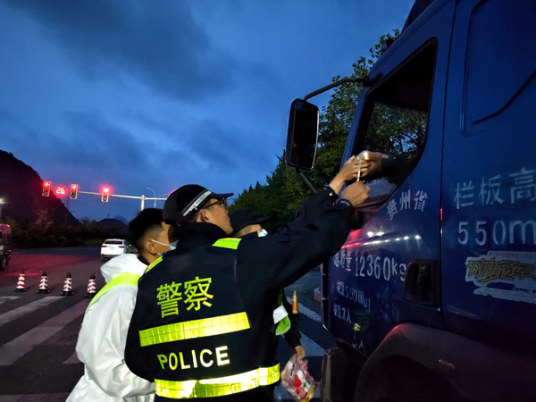 4---图为安顺市公安局—民警为卡点上的司机送饭。安顺市公安局供图