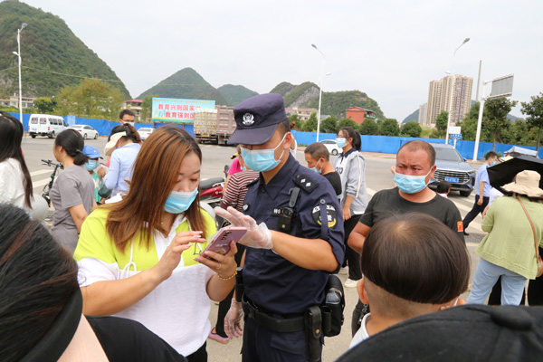 7--图为安顺市公安局--民警帮助群众在手机上如何操作核酸检测。安顺市公安局供图.