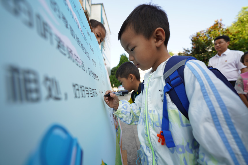 9月5日，在貴州省丹寨縣城關一小，一年級新生在入學“簽名牆”上簽名。