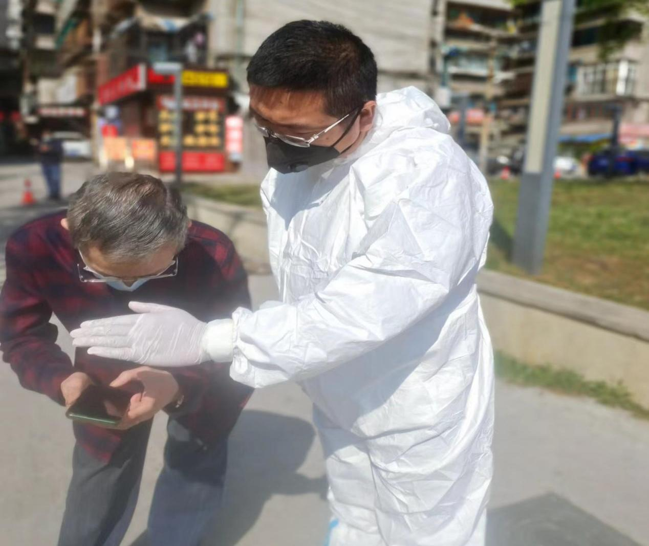 云岩支行罗福坤帮助居民操作核酸检测流程。