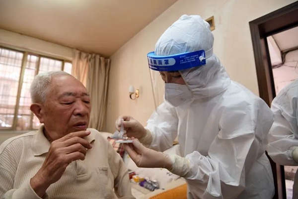 工作人員上門指導老年人進行抗原檢測。