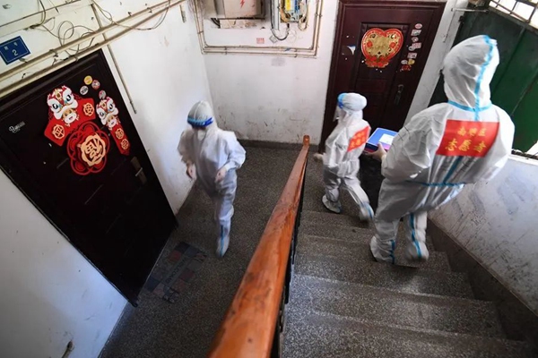 工作人员在辖区楼梯内发放抗原检测试剂。