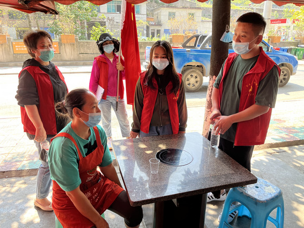 志愿者与动员社区群众开展全民核酸检测。