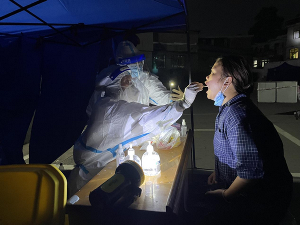 医疗志愿者深夜为市民进行核酸采集。
