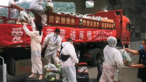 沙冲路街道工作人员及志愿者正在搬运蔬菜包。