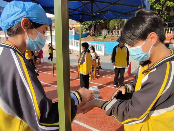 学生志愿者开展测温防疫工作。