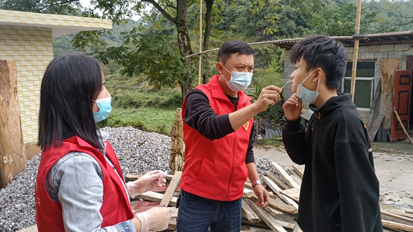 2022年9月13日，纳雍县水东镇独山村，志愿者在给小朋友做抗原。