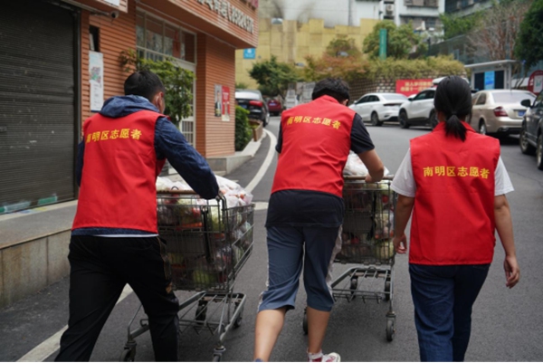 田霞等志愿者在为居民送蔬菜的路上。