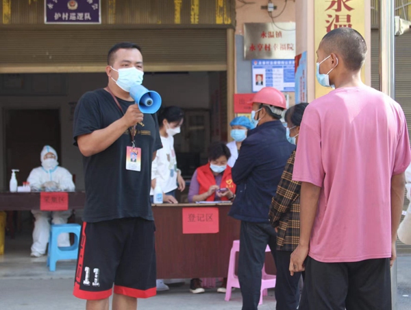图为：工作人员用小喇叭新冠肺炎防控知识