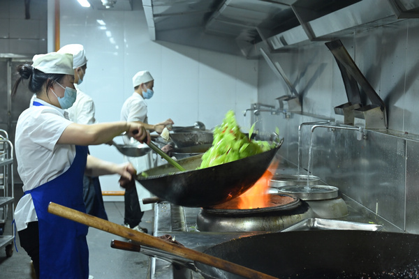 贵州大学学生食堂正在炒菜的厨师。杨吉珩摄