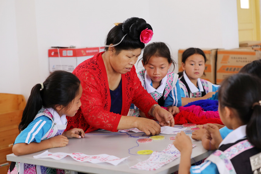 9月20日，民族文化課輔導老師在指導學生學習苗族刺繡。 