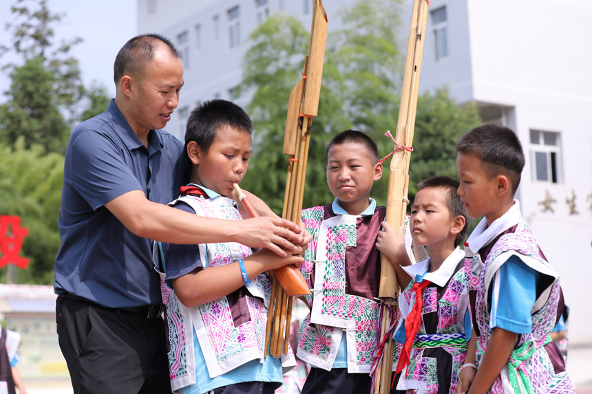 9月20日，老師在指導學生吹蘆笙。
