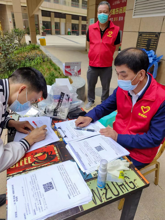 李昌顺在云开街道云开国际小区核酸检测点给居民登记信息。