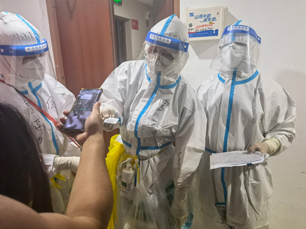 杨光亮与医护人员上门为居民进行核酸检测（右起第一人）。