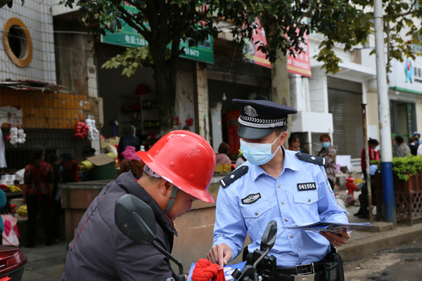 图为民警以和群众“摆龙门阵”的方式普及防诈骗知识。