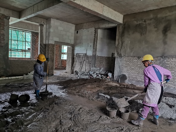 2.在開陽縣第一幼兒園分園建設項目，工人正在攪拌水泥砂漿。