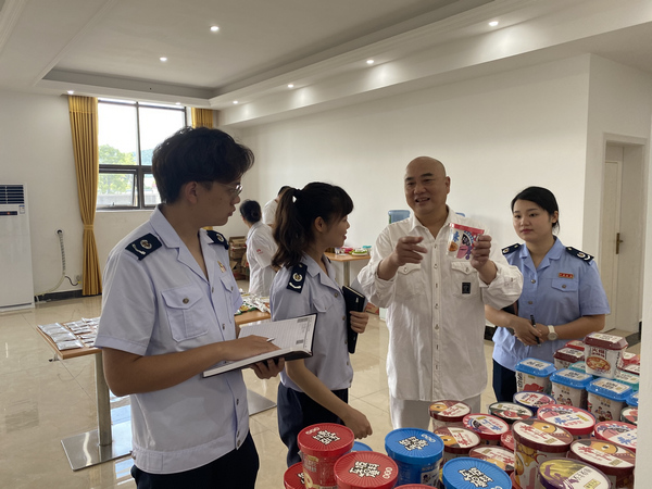 在贵州李记食品有限公司产品展示台前，公司董事长李国斌向到访的税务人员介绍泡菜系列产品。谭飞摄