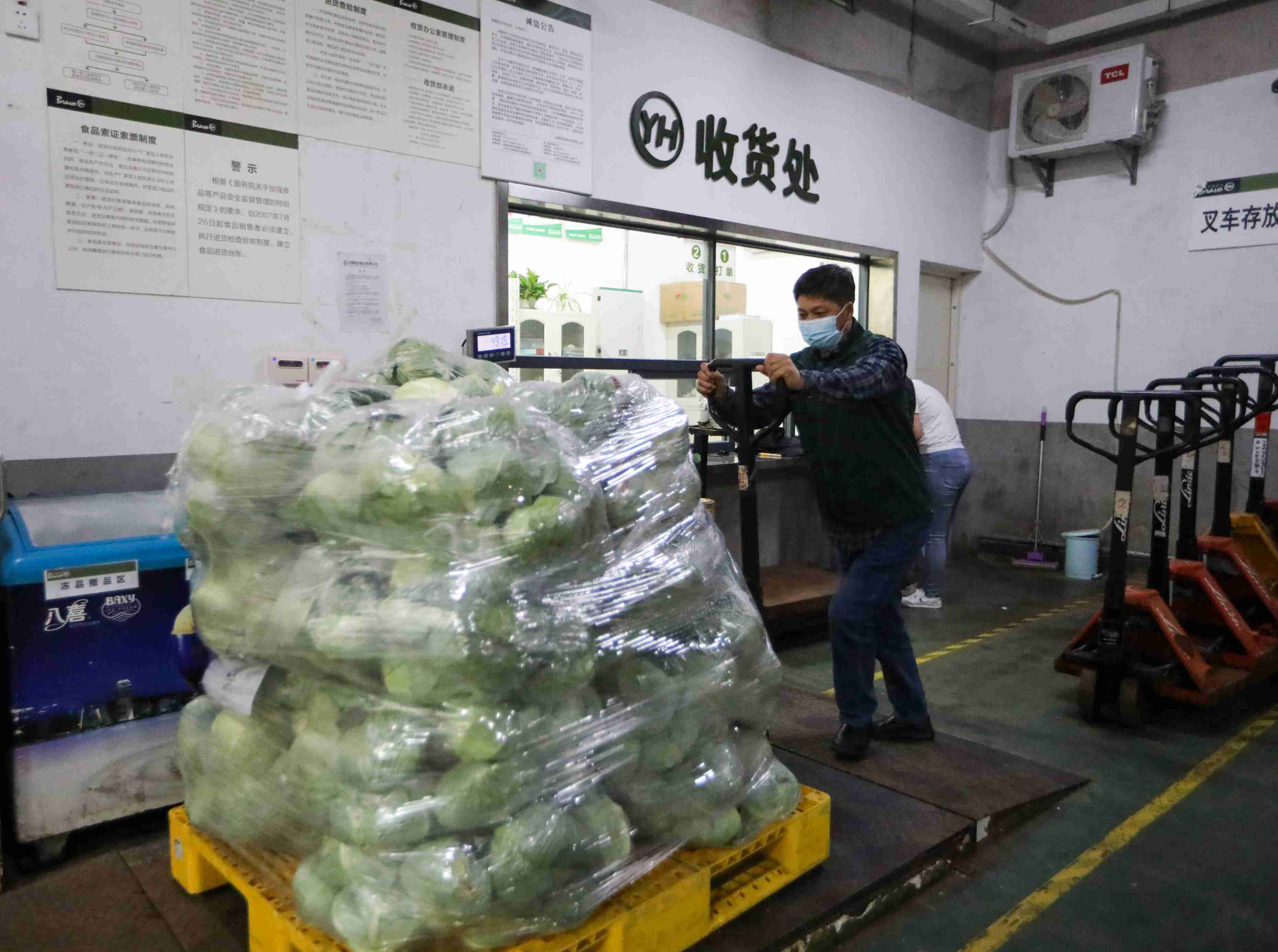 永辉超市工作人员正在转运蔬菜。