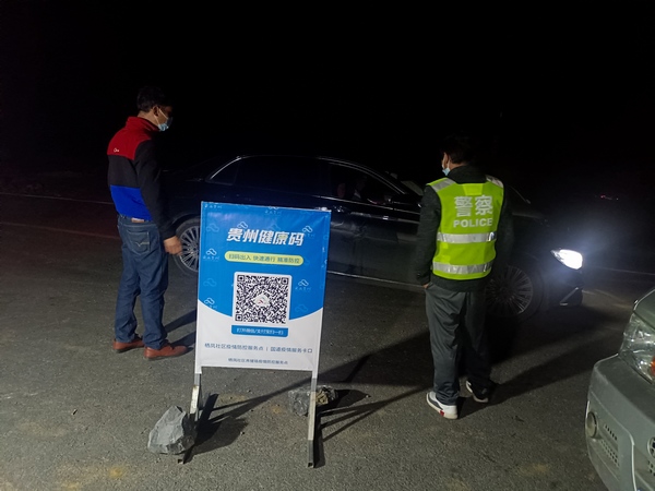 大方县凤山乡马干山疫情防控服务点工作人员夜间对过往车辆进行排查。