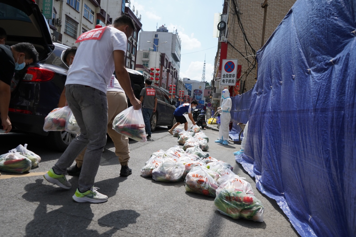 金沙县鼓场街道的汇金大厦小区工作人员正在为居民送蔬菜包。