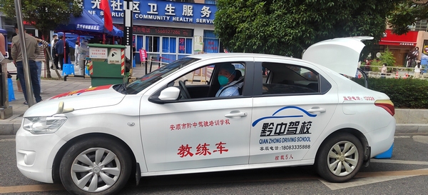 驾校教练员为核酸样本转运。