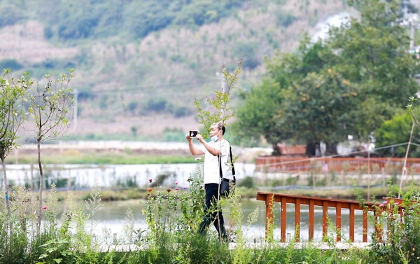 游客在大方县黄泥塘化联社区拉荒田园游玩拍照。周训贵摄