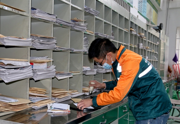 納雍縣郵政公司郵件處理中心，員工在蓋郵戳。