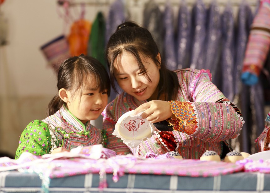 2022年10月30日，志願者（右一）在貴州省黔西市紅林彝族苗族鄉漁塘村新時代文明實踐站指導小朋友學習刺繡。