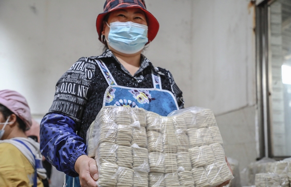 10月31日，工人在大方縣六龍鎮山水豆干作坊搬運制作好的豆干。周訓貴攝