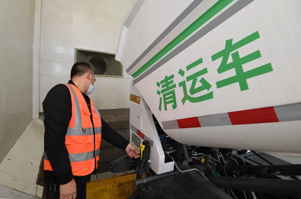环卫工人操作垃圾清运车在南明区红岩生活垃圾分拣中心倒料口倒料。