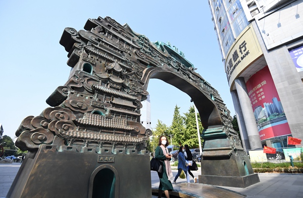 1月4日，市民正從貴陽市南明區青雲路步行街由九門四閣元素構成的青雲門雕塑中穿行。