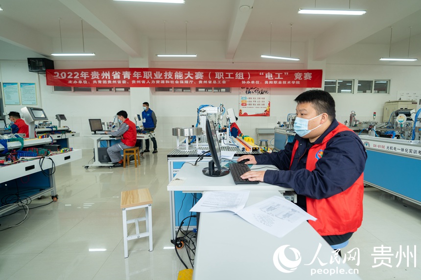 “电工”赛项参赛选手正在进行工业控制系统的编程与调试比拼。人民网记者 涂敏摄