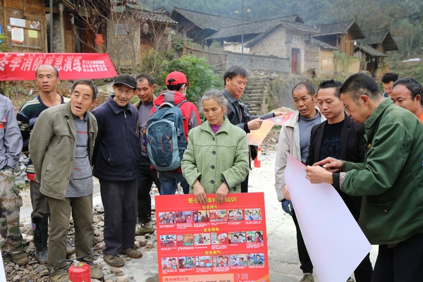 圖為向農村老人科普防火知識、發放宣傳圖冊。